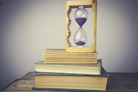 Books on Wood Table With Hourglass