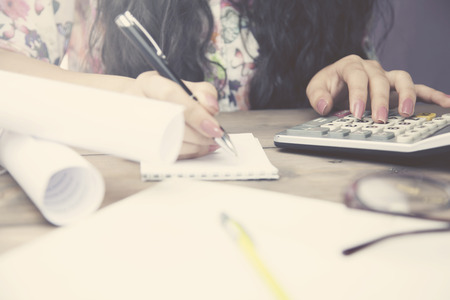 woman hand calculator and pen on working tableの写真素材