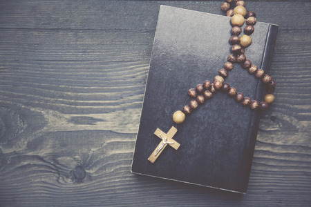 cross on book on wooden table