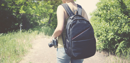 young woman with backpack and cameraの写真素材