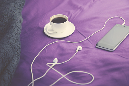 cup of coffee and phone on bedの写真素材
