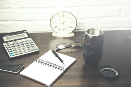 Notebook and office accessories on wood tableの写真素材