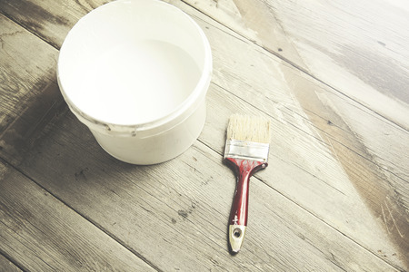paint brush on can lying on wooden tableの写真素材