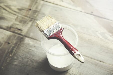 paint brush on can lying on wooden tableの写真素材