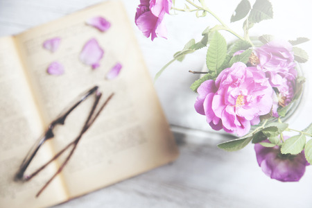 Pink roses in vase,books on wooden tableの写真素材