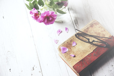 Pink roses in vase,books on wooden tableの写真素材