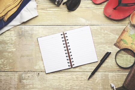 Items include,  sweater, camera, film, binoculars, passport, wallet, map, compass and  notebookの写真素材