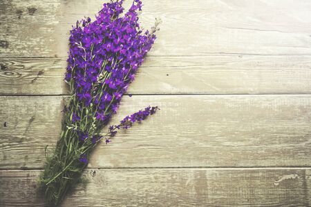 purple flowers on wooden table backgroundの写真素材