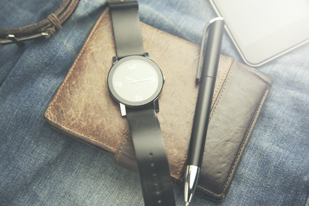 watch, wallet,phone and pen  on jeans