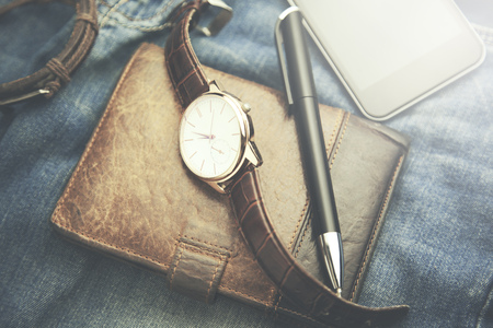 watch, wallet,phone and pen  on jeans