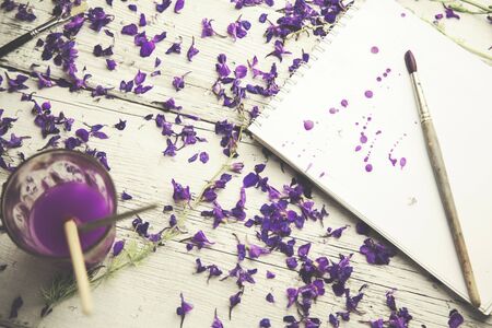 flower petals, watercolor, brush and notebook on tableの写真素材