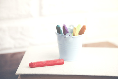 Books and pencils on a wooden table. On brick wall background.の写真素材