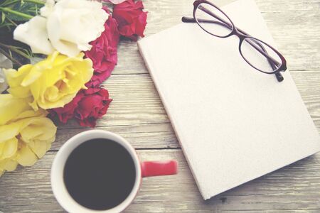 roses,coffee and book on wooden  table