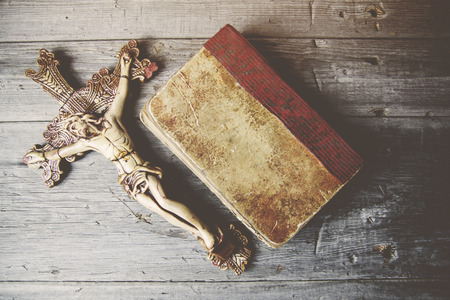 Crosses and book on a wooden tableの写真素材
