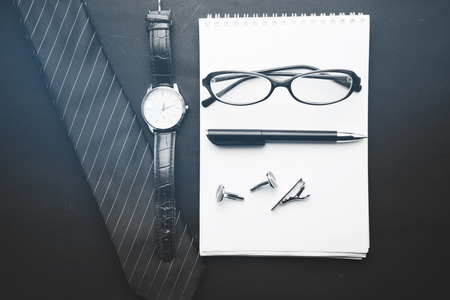 tie,notebook,glasses,watch  and coffee on  black backgroundの写真素材