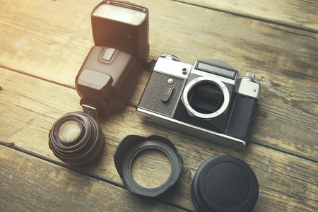 Old film camera and  lenses on a wooden background