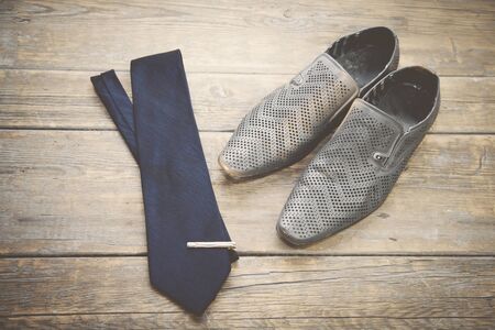 Man shoes and tie on wooden backgroundの写真素材