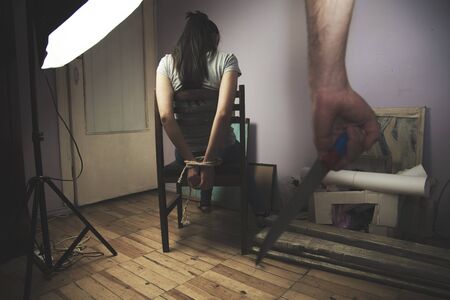 Scared woman threatened by a man with bloody knifeの写真素材