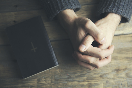 Young man  praying and bible on tableの写真素材