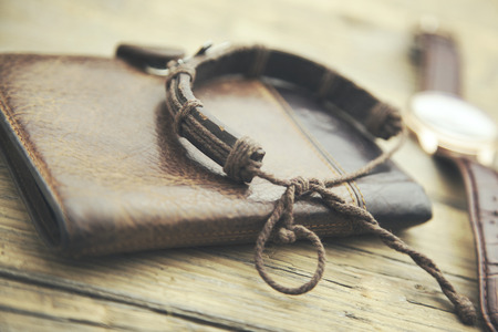 elegant watch, wallet and bracelet on wooden tableの写真素材