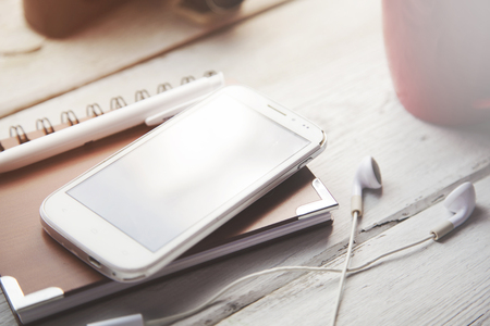 Office table with notepad, coffee cup , pen , smartphone , headphoneの写真素材