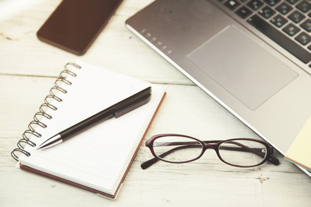 laptop and note paper on the wood texture backgroundの写真素材