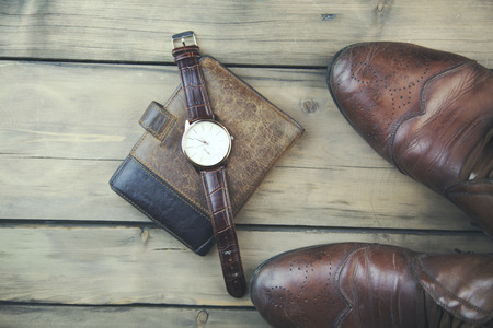 shoes, wallet and watch on wooden table