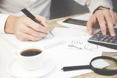 A Businessman Calculating Bills Using Calculatorの写真素材