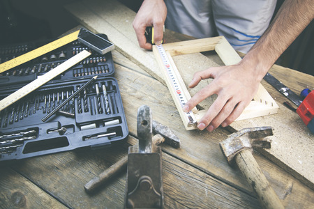 Builder measuring boards length, roulette for measuring, ruler in the hand of workerの写真素材