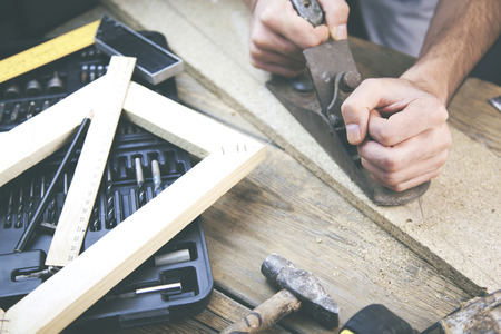 Artist canvas on man hand , canvas stretcher and staple gun on table