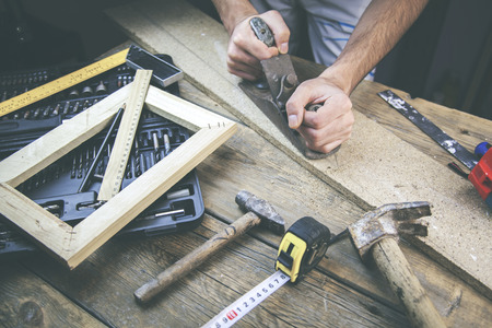 Artist canvas on man hand , canvas stretcher and staple gun on tableの写真素材