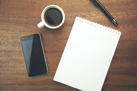 desk with a cup of coffee, a notebook and penの写真素材