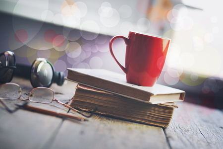 Porcelain cup with coffee on books by the window backgroundの写真素材
