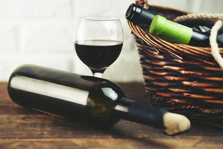 Wine bottles in basket on wooden tableの写真素材