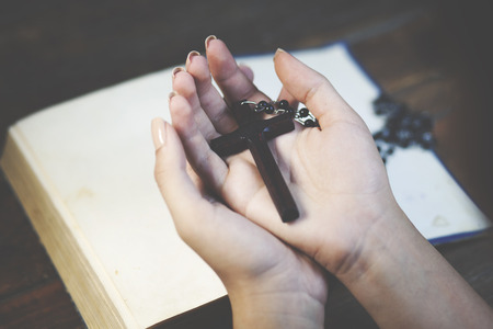 Woman praying with her bible on tableの写真素材