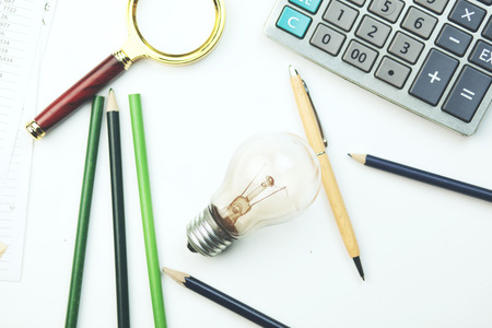 bulb, notebook and calculator on working