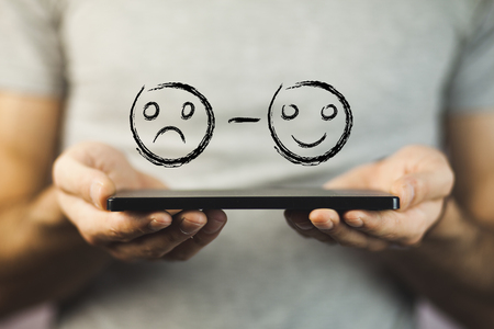 Unhappy and Happy Smileys on Human Handの写真素材