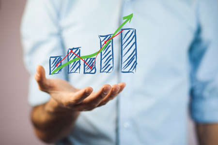 businessman with financial symbols coming from handの写真素材