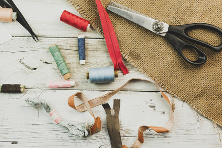 Vintage Background with sewing tools and colored tape/Sewing kit. Scissors, bobbins with thread and...