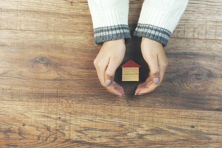 woman hand house model on wooden tableの写真素材