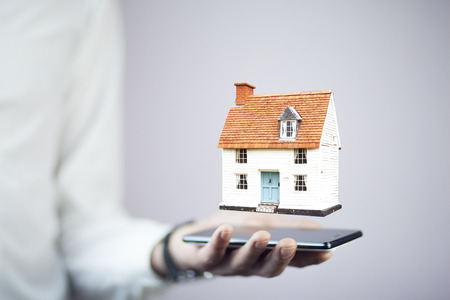 Man hand phone with house model on white backgroundの写真素材