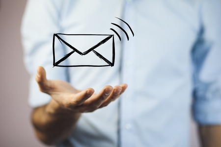 man holds a virtual postal envelope, concept of email, internet and networkingの写真素材