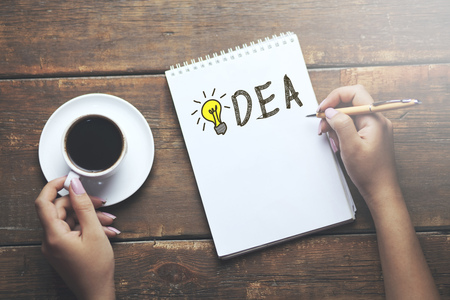 idea concepts-Woman painting bulb on notebookの写真素材