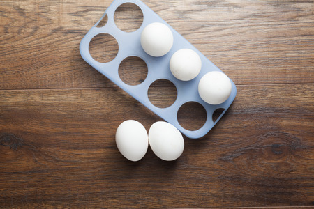 Many white eggs on the wooden table