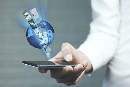 Businessman holding world and phone.Technology concept