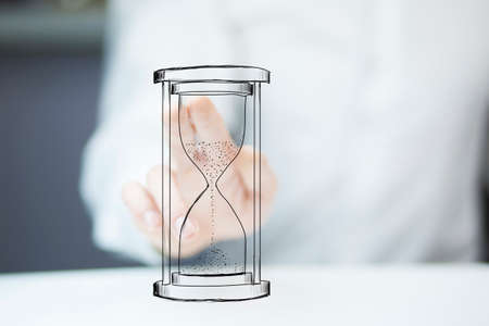 Man's hand holding hourglass sandの写真素材
