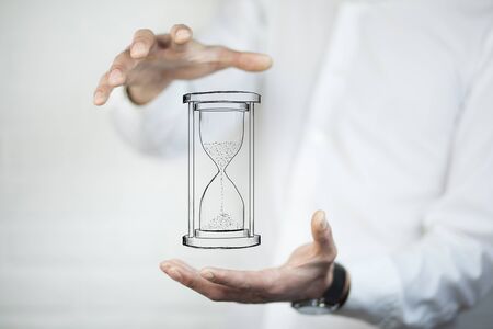 Man's hand holding hourglass sand 