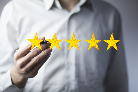 View of a Businessman hand pen  touching technology interface with ranking stars