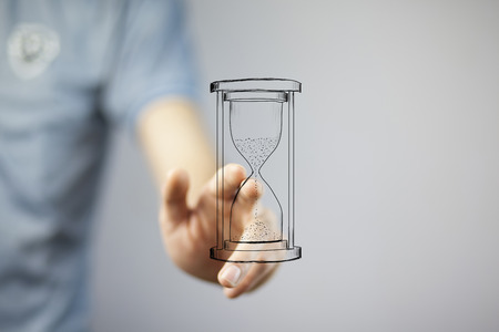 Close up of businessman holding sandglass in handの写真素材