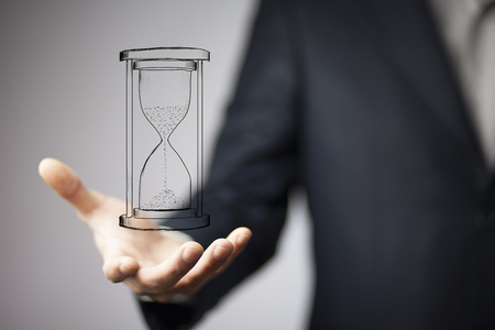 Close up of businessman holding sandglass in hand